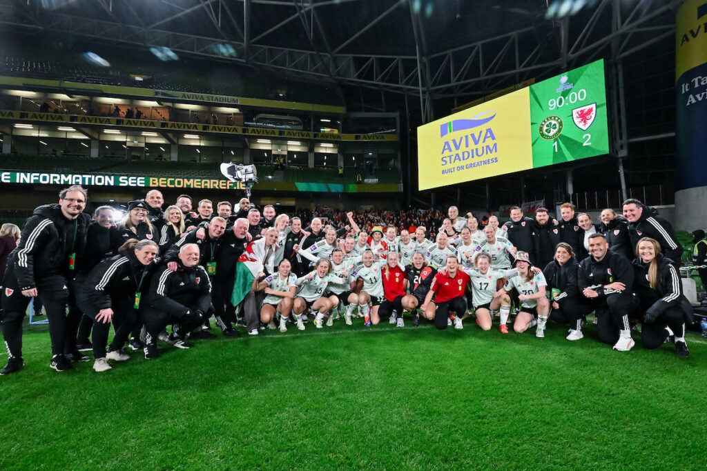 The Cymru squad and staff celebrate at the Aviva Stadium after beating the Republic of Ireland to qualify for WEURO 2025