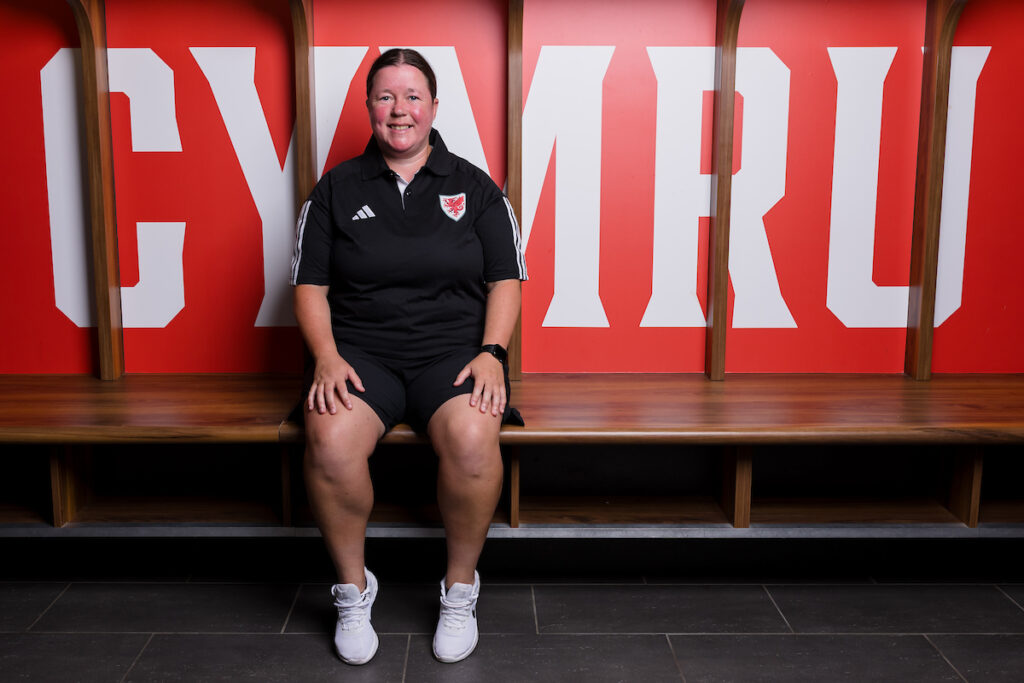 WU17 Head Coach Natalie Lawrence sat in the Cymru dressing room